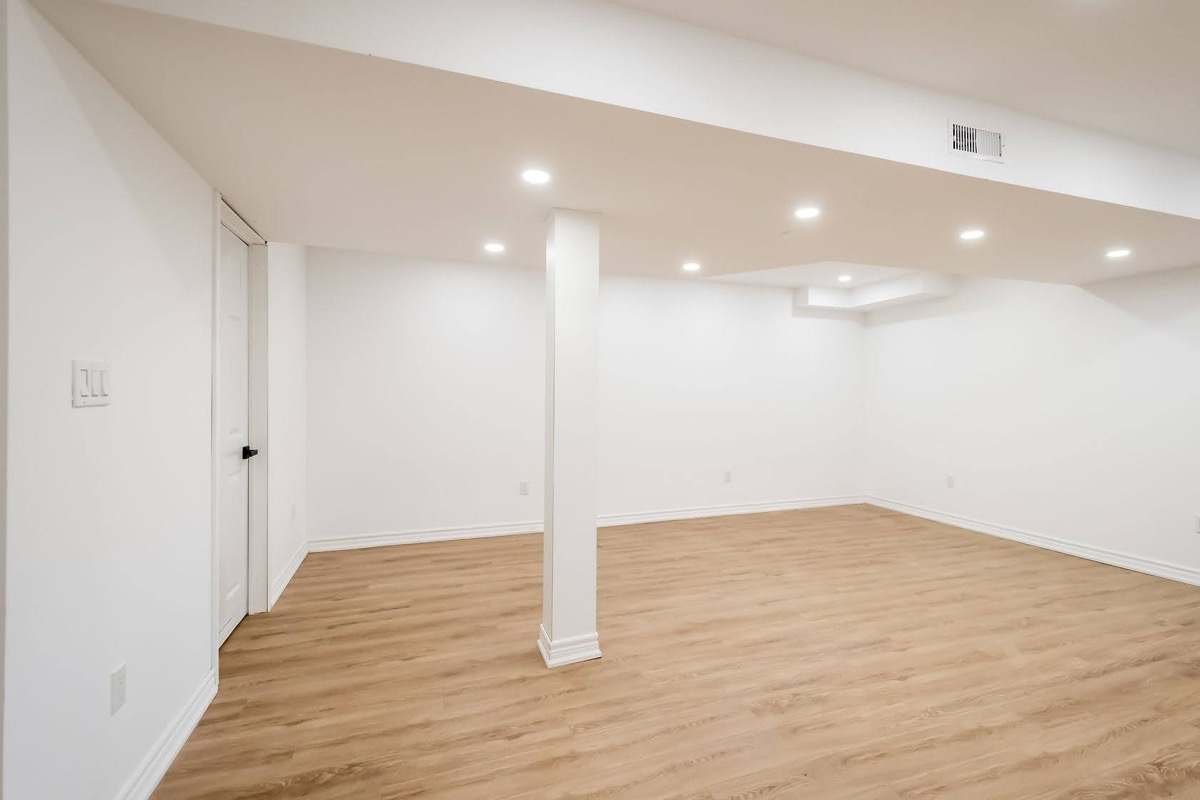 Clean finished basement with excellent lighting and professional staging — premium portfolio shot showing complete transformation — Stonehenge, Hamilton | MTC Renovations