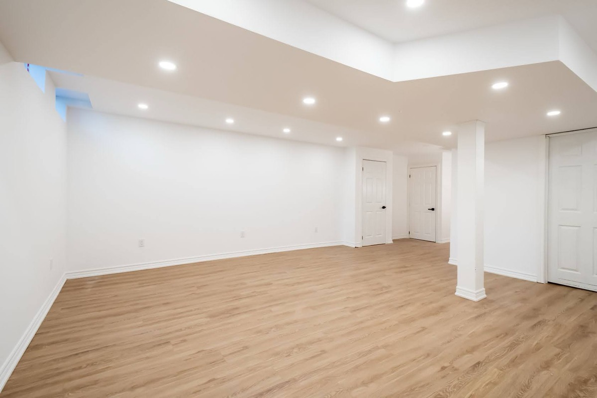 Bright finished basement with excellent recessed lighting and quality flooring — premium portfolio shot for virtual tours and marketing — Stonehenge, Hamilton | MTC Renovations