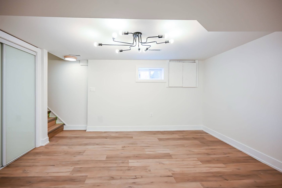 Clean finished basement with quality hardwood flooring and modern lighting — excellent wide-angle portfolio shot — Winchester, Hamilton | MTC Renovations