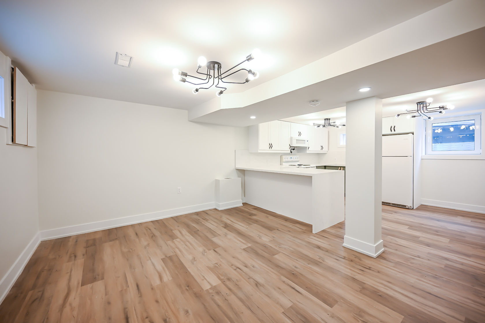 Clean finished basement suite with modern fixtures and beautiful hardwood — excellent wide-angle portfolio shot — Winchester, Hamilton | MTC Renovations
