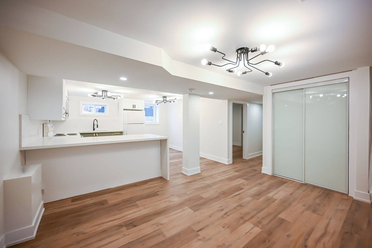 Bright finished basement suite with modern fixtures and beautiful hardwood — premium portfolio shot — Winchester, Hamilton | MTC Renovations
