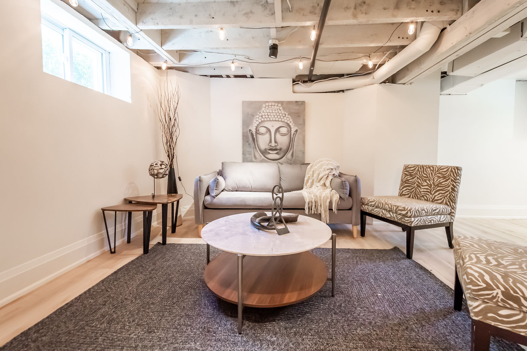 Beautifully staged finished basement with exposed beams, professional lighting, and aspirational furniture — premium portfolio shot — Rosedene, Hamilton | MTC Renovations