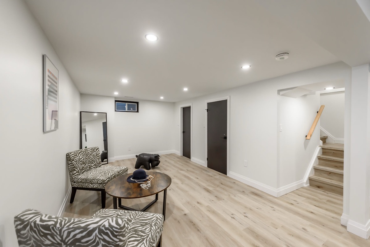 Bright finished basement with excellent staging and wide-angle composition — premium portfolio shot showing complete transformation — Gateshead, Hamilton | MTC Renovations