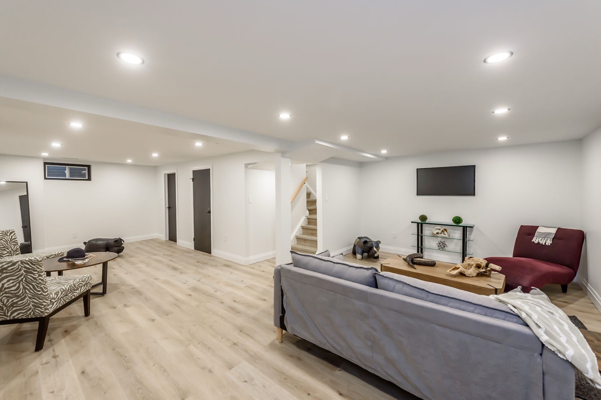 Bright finished basement with excellent staging and wide-angle composition — premium portfolio shot showing complete transformation — Gateshead, Hamilton | MTC Renovations