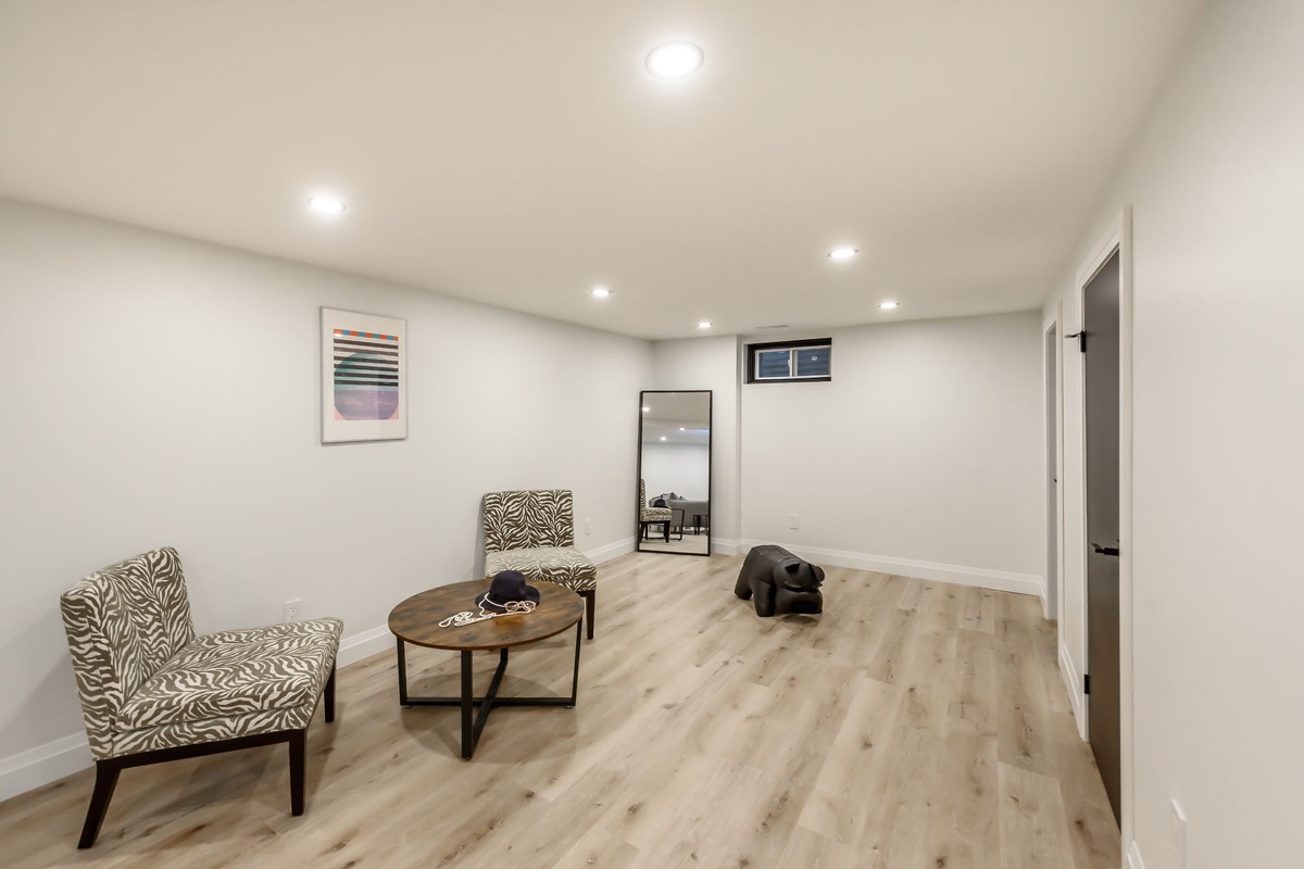 Clean finished basement with warm lighting and quality flooring — strong portfolio piece showing livable space transformation — Gateshead, Hamilton | MTC Renovations